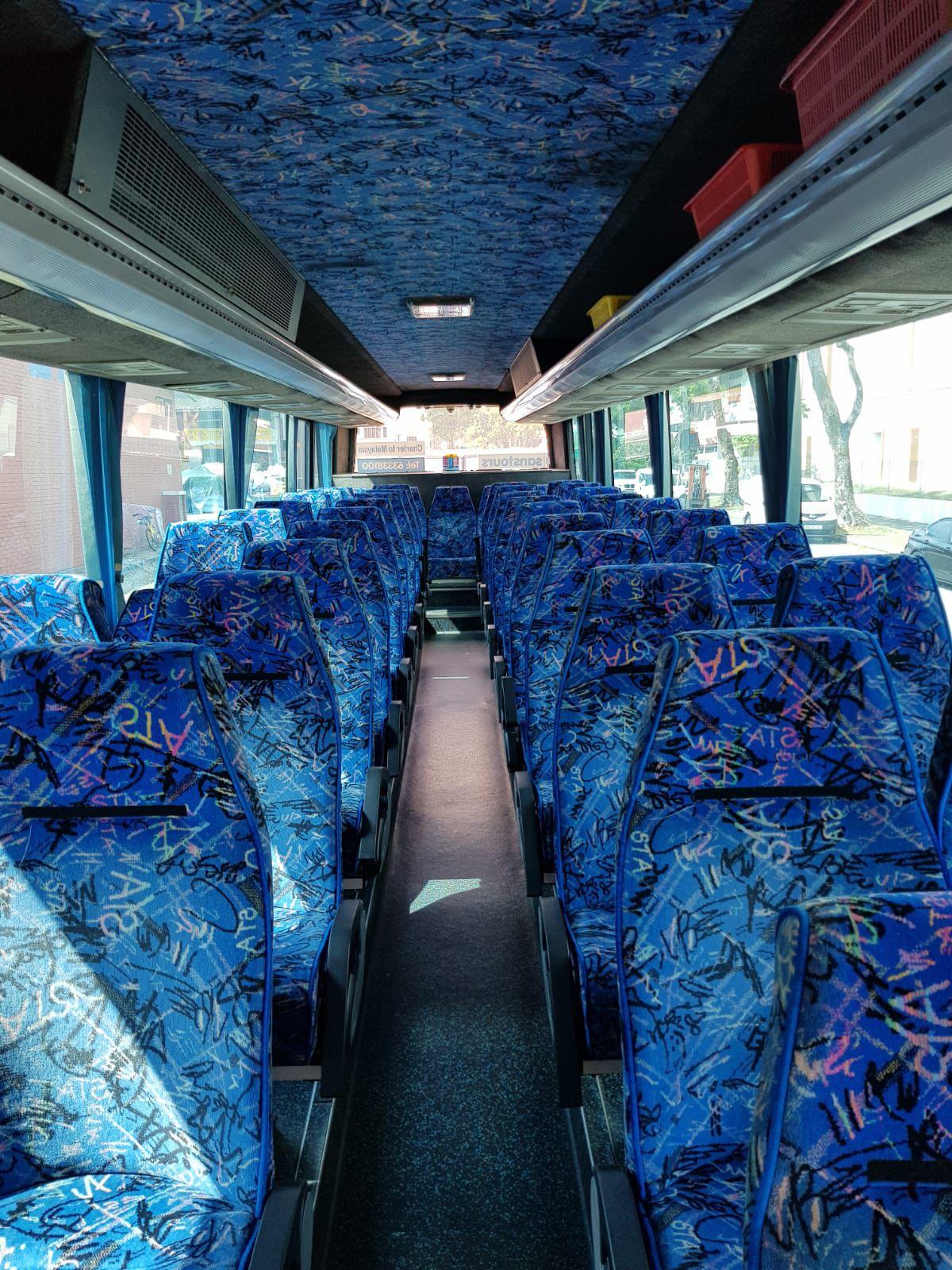 Large charter coach interior with blue patterned seats